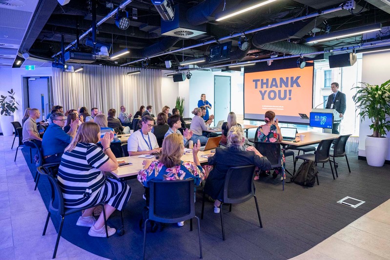 Educators seated at round tables during the student-led session at the E3 Unconference in Sydney, with a 'Thank you' slide on screen.