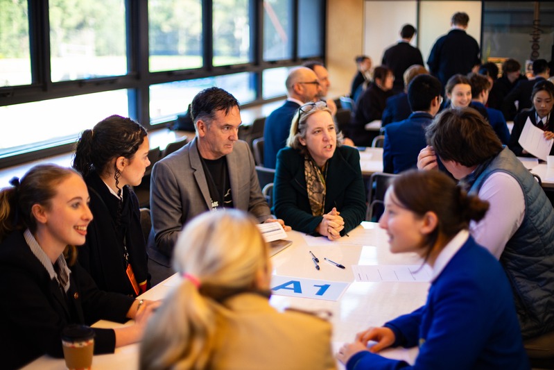 Students, educators and industry guests in discussion around a table at the NBCS summit.